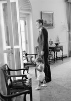 President John F. Kennedy and his son in the Oval Office